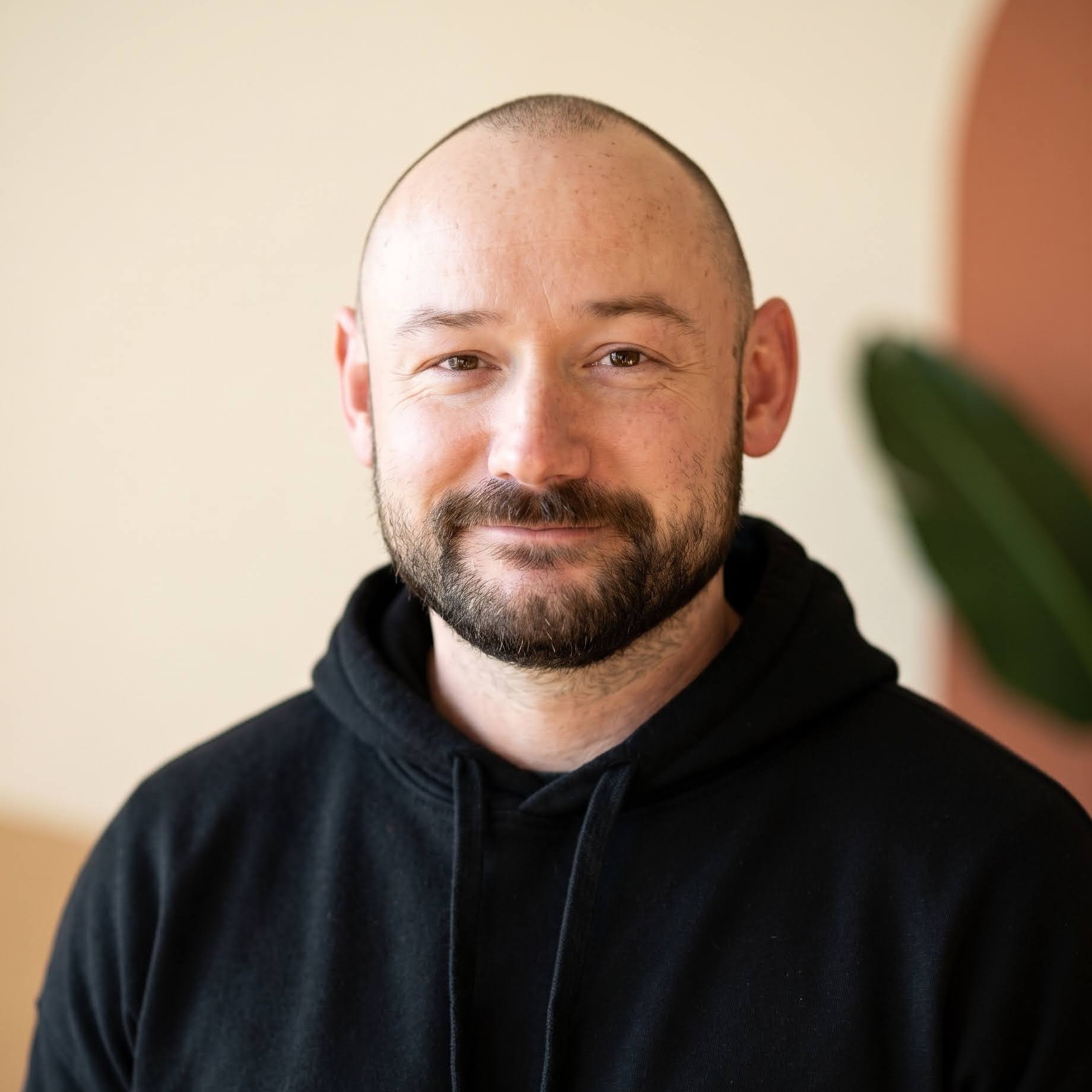 Portrait of Corey smiling while wearing a black hoodie