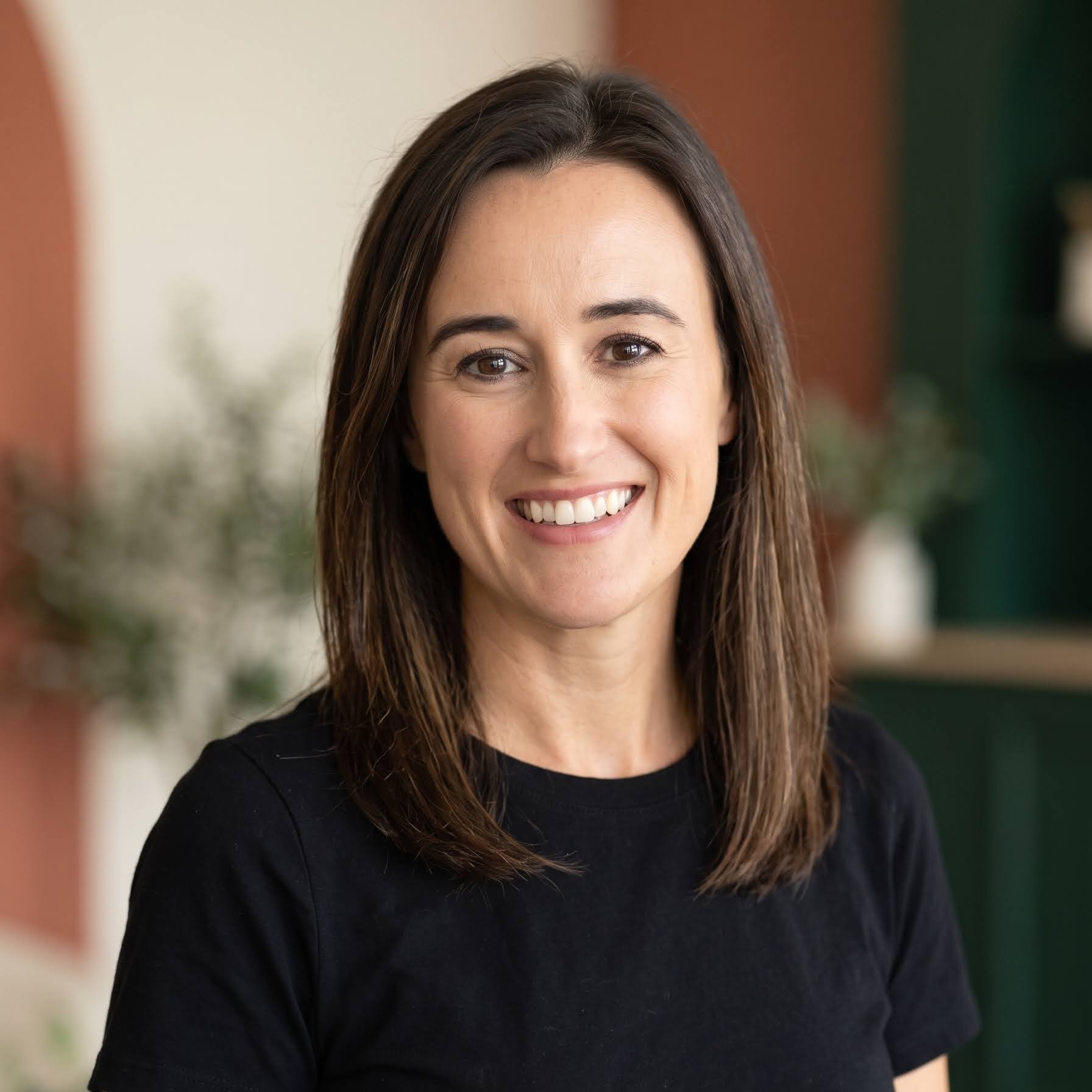 Portrait of Steph smiling while wearing a black shirt